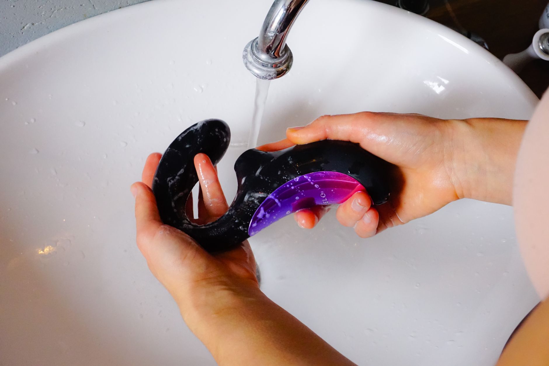 Cleaning a sex doll with mild soap and water to maintain hygiene and appearance.